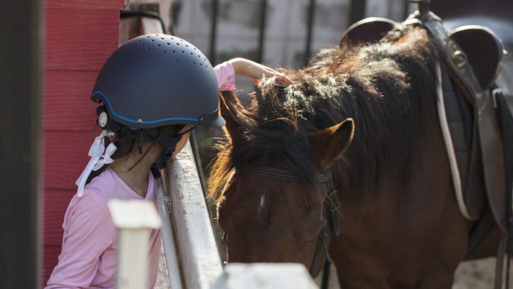 asian school kid girl with horse riding practicing horse ridding horse ranch